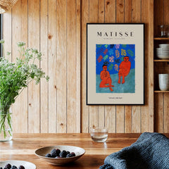 Matisse Art Prints -  Two Figures Flute Poster displayed on a wooden wall, featuring expressive orange figures and vibrant colors.