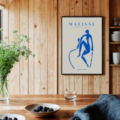 Matisse Art Prints -  Blue Nude Seated Figure Poster displayed in a modern interior with flowers and tableware.