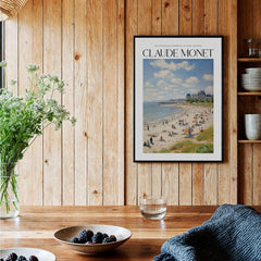 Claude Monet Sunny Beach Day Wall Art - Coastal Resort Scene Print displayed on a wooden wall with greenery and decor.