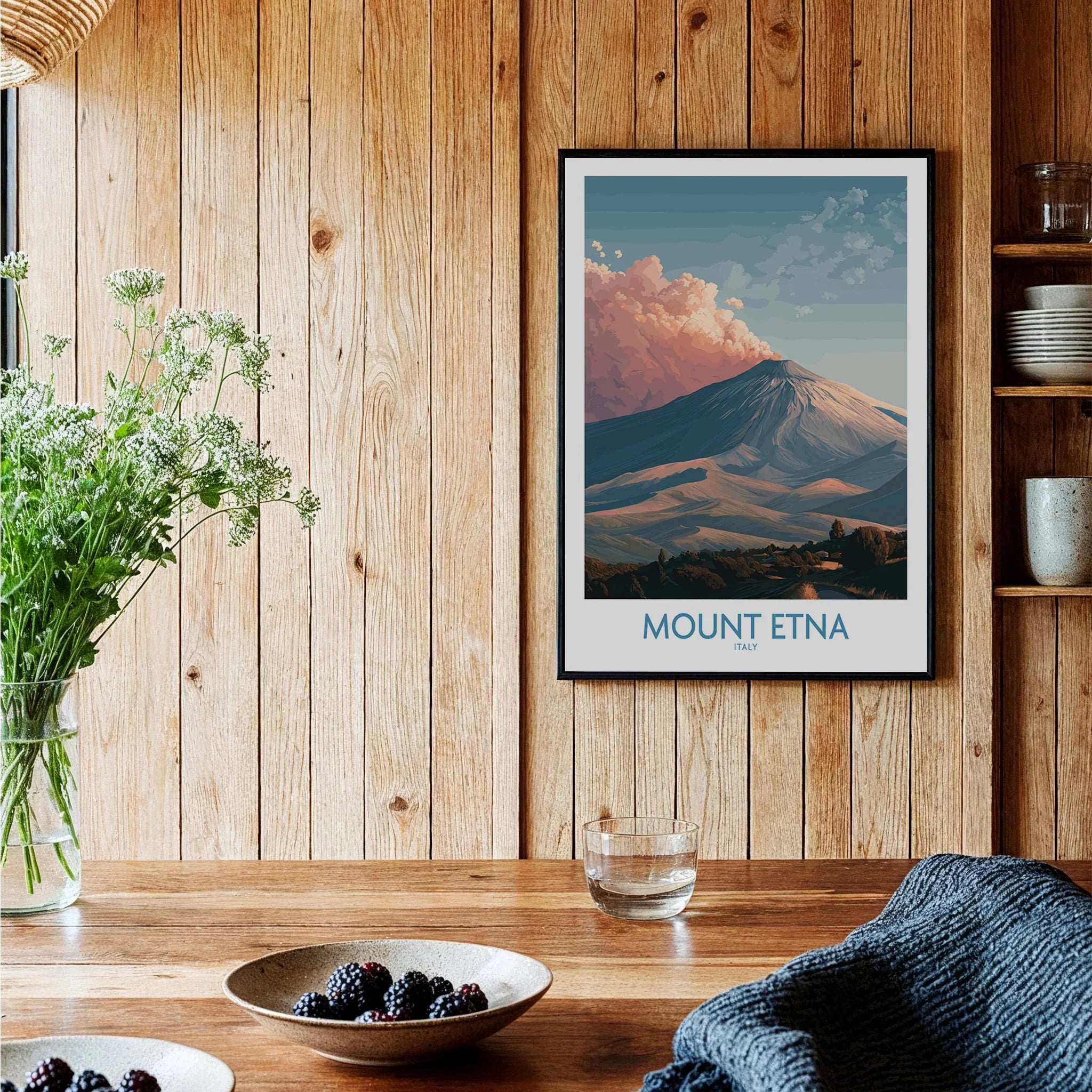 Framed Mount Etna travel poster on wood wall in cozy kitchen setting with berries on table