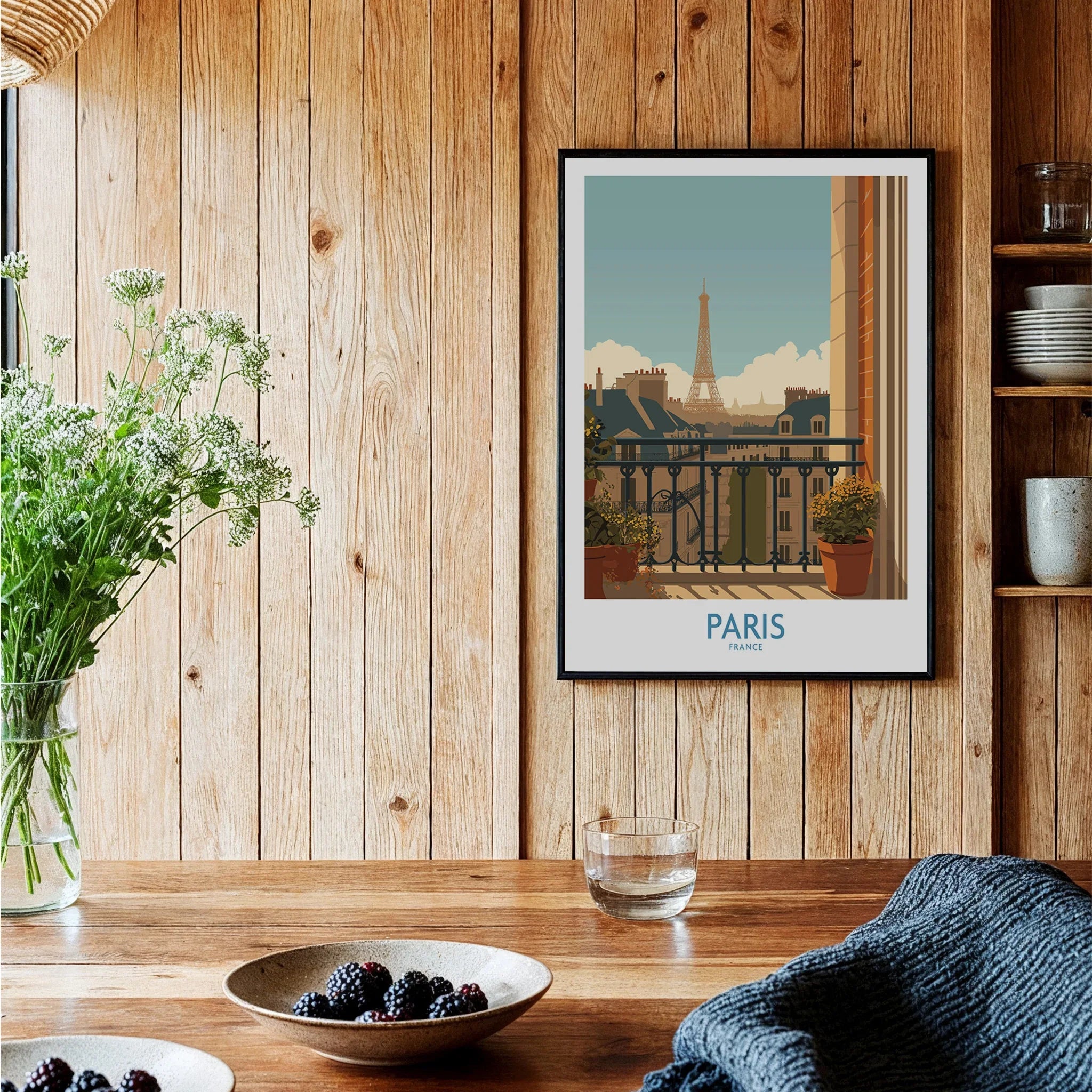 Paris travel poster art print in black frame displayed on wooden kitchen wall