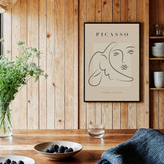 Picasso Line Art Face Dove Minimalist Modern Gallery Poster Print displayed in a stylish interior with wooden accents.