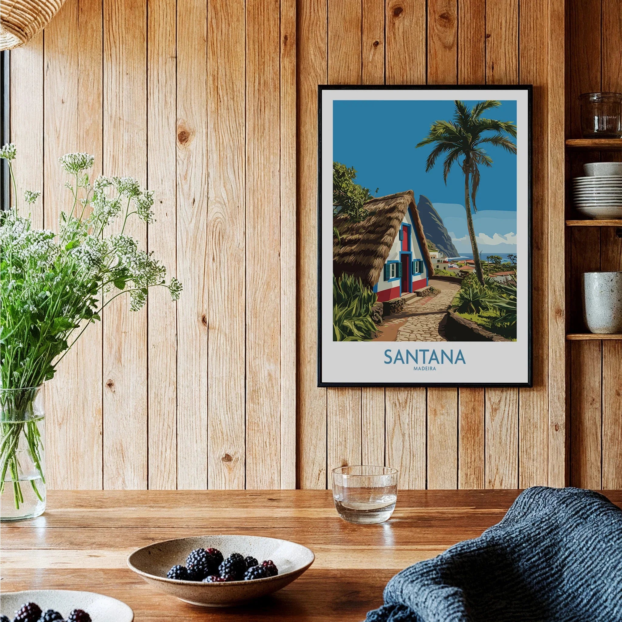 Santana Madeira travel poster in black frame on wood wall in rustic kitchen setting.