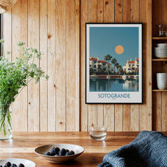 Sotogrande Spain Canvas Print | Mediterranean Waterfront Scenery Poster framed on wooden wall with plants and table setting.