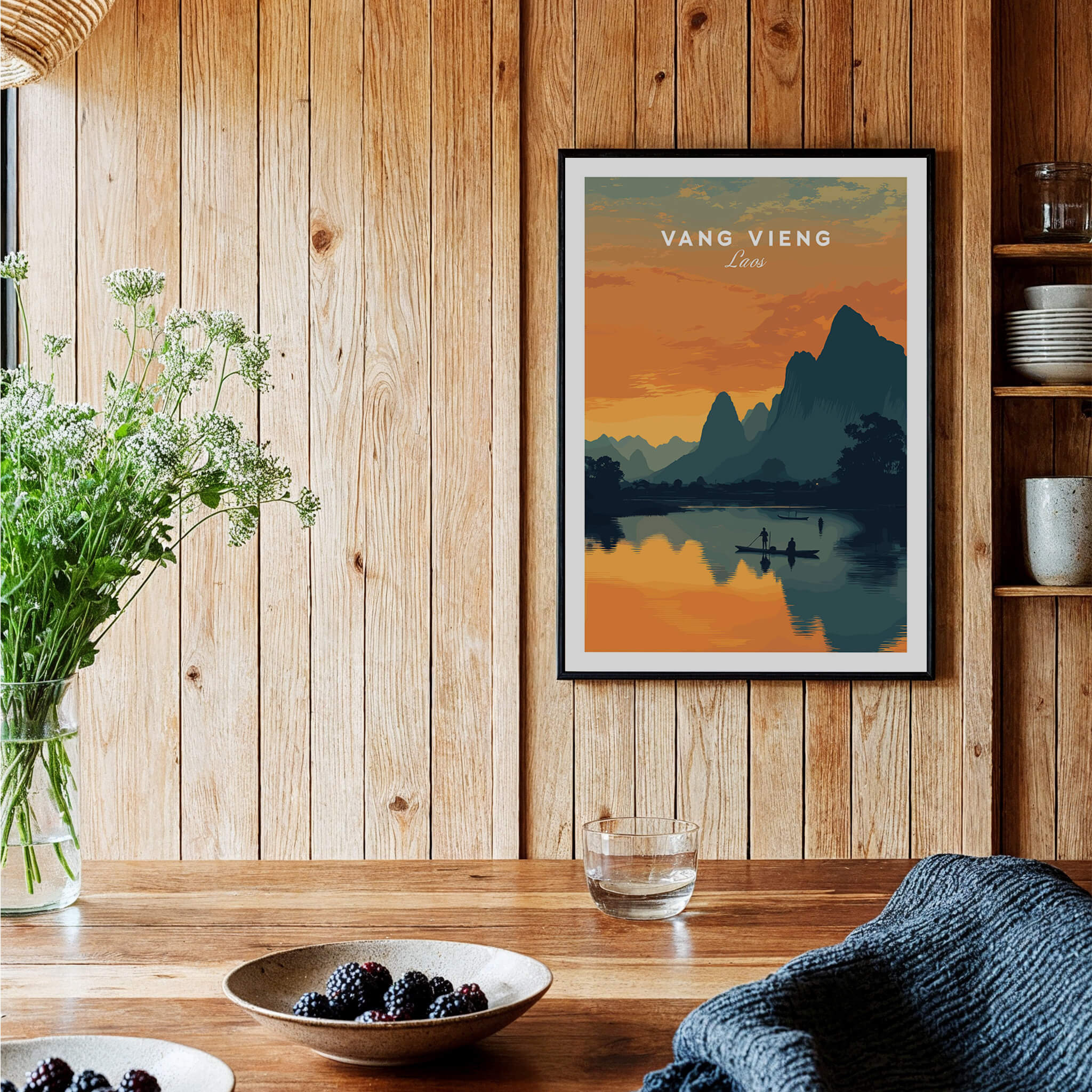 Vang Vieng Laos Travel Poster | Nam Song River Sunset Wall Art Print displayed on a wooden wall with flowers and a cozy setting.