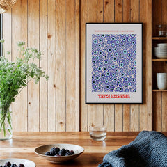 Yayoi Kusama Evil Eye Pattern Blue Contemporary Art Print Poster Paris Wall Decor framed on a wooden wall with decor.