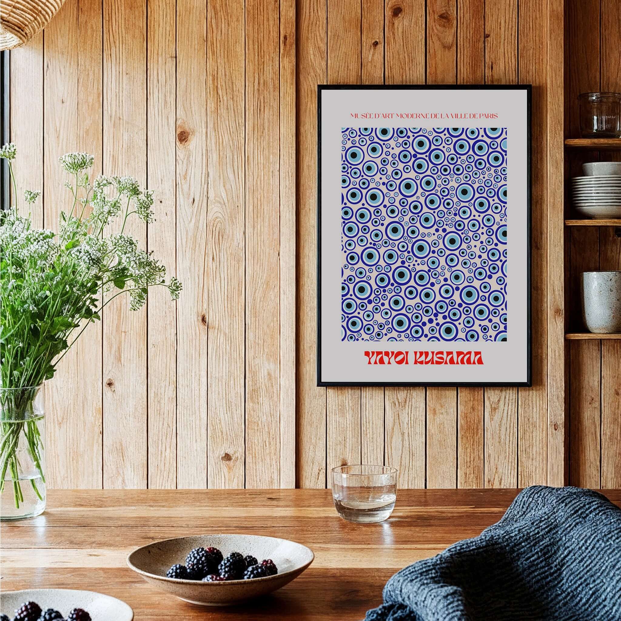 Yayoi Kusama Evil Eye Pattern Blue Contemporary Art Print Poster Paris Wall Decor framed on a wooden wall with decor.
