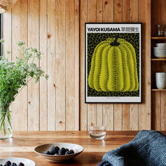 Yayoi Kusama Yellow Black Pumpkin 1991 Hong Kong Art Print Poster Polka Dot Decor on wooden wall with table.