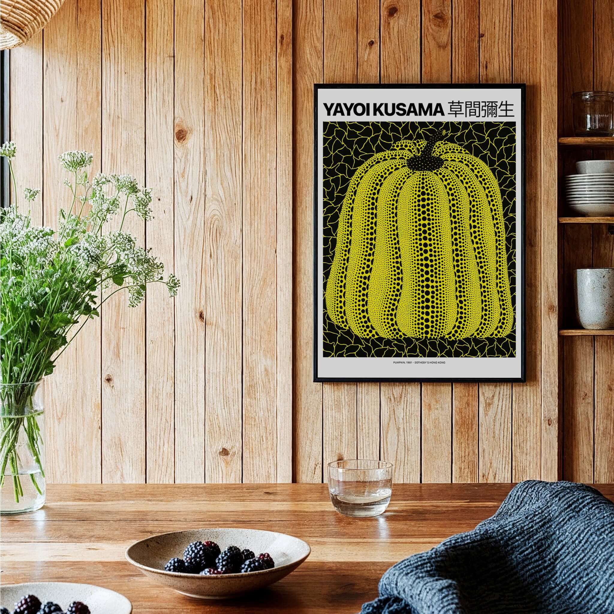 Yayoi Kusama Yellow Black Pumpkin 1991 Hong Kong Art Print Poster Polka Dot Decor on wooden wall with table.