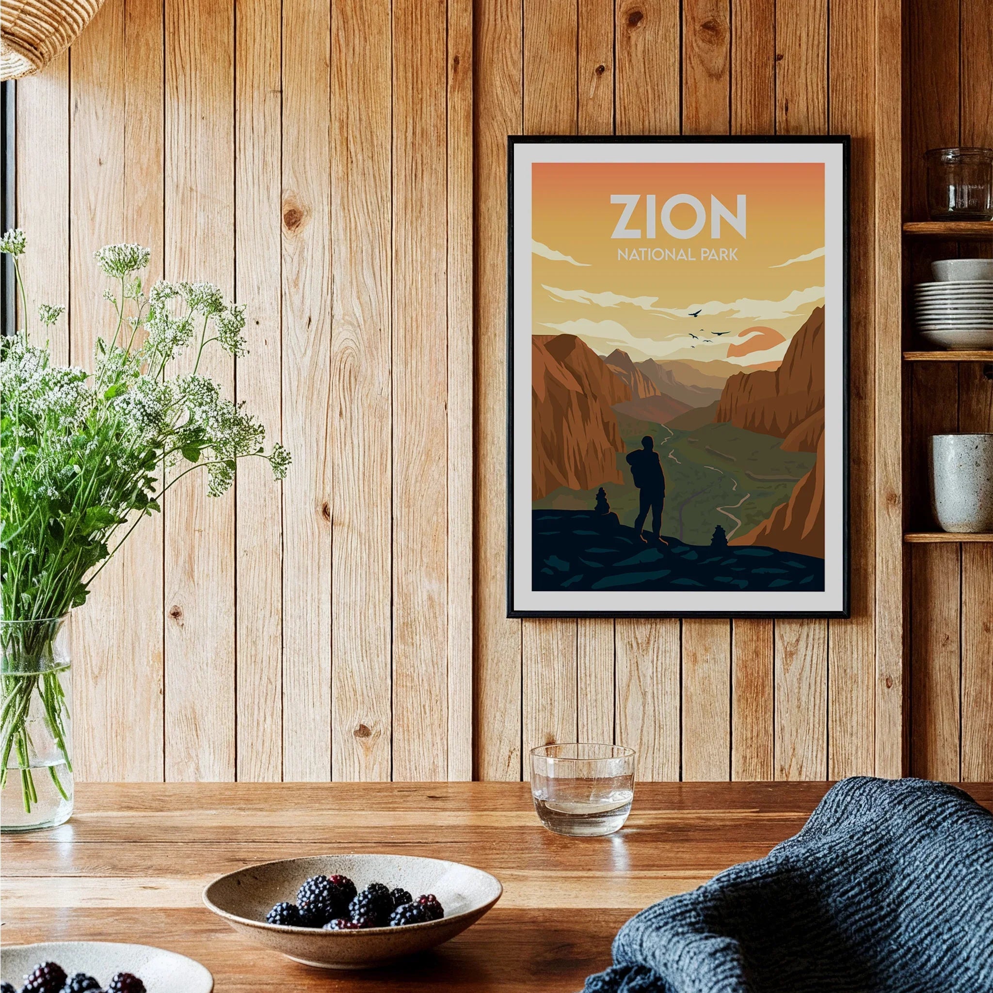 Zion National Park art print in black frame hanging in rustic kitchen with wood walls.