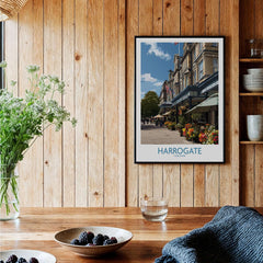 Harrogate Yorkshire Art Print | Floral Cafe Scene Poster displayed in a cozy wooden interior with a vase of flowers.