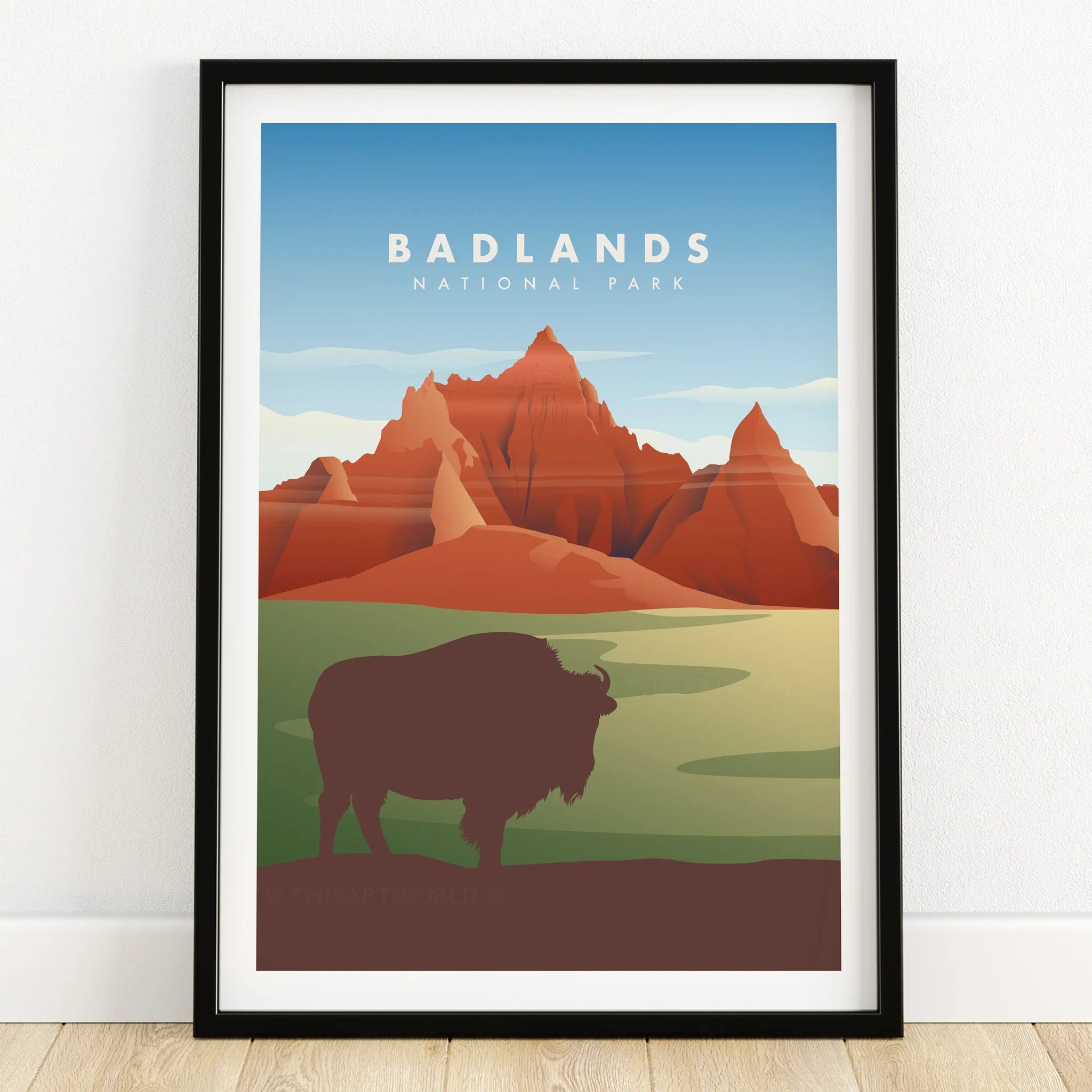 Badlands National Park art print with bison silhouette, red rock formations, and blue sky in black frame