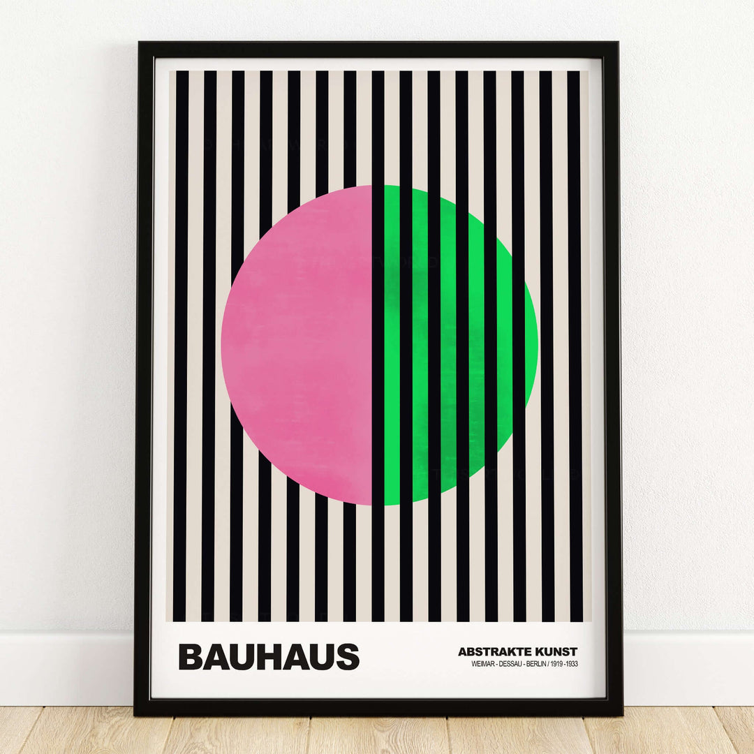Bauhaus Exhibition Prints - Split Circle Abstract Art Print Pink Green Stripes in a frame with black and cream stripes.