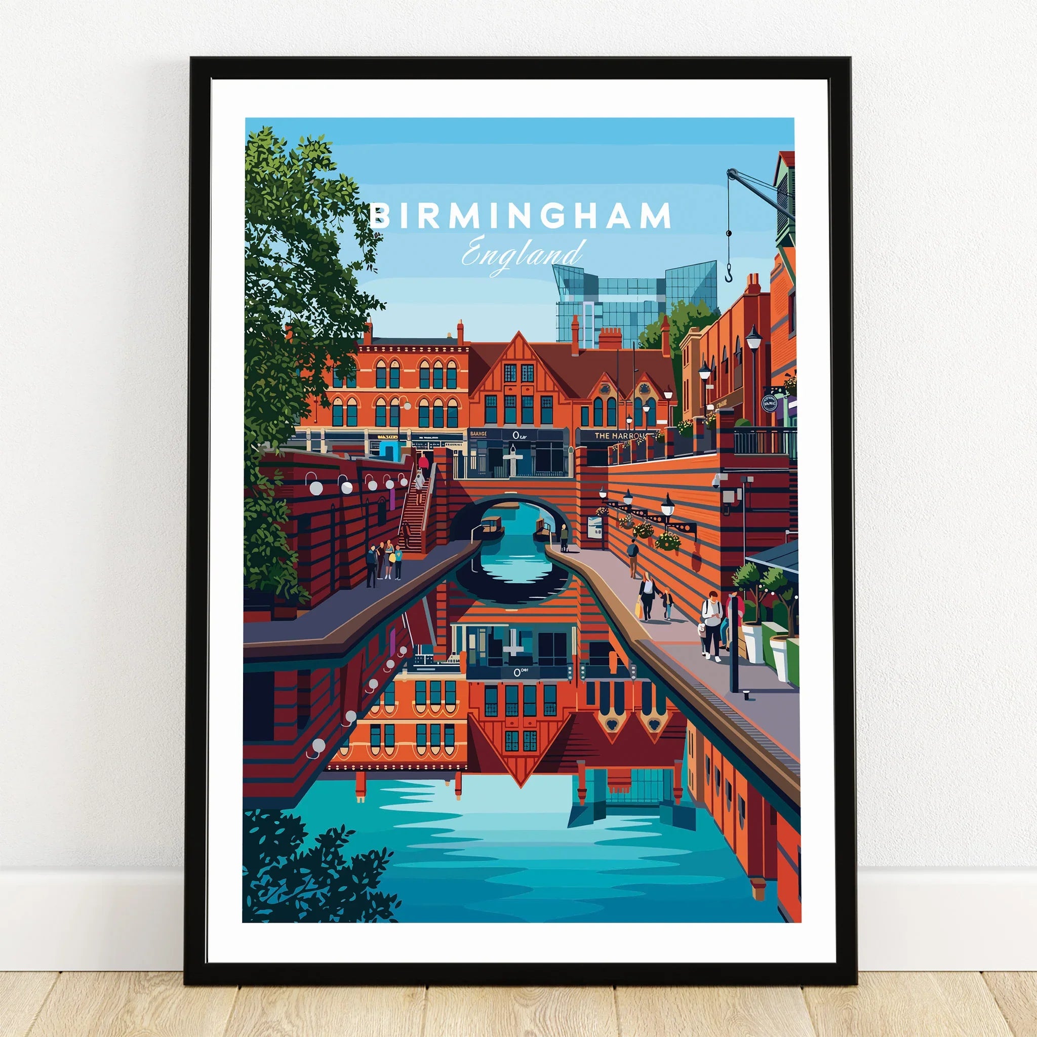 Birmingham England art print in black frame, featuring city canal and skyline, on wooden floor