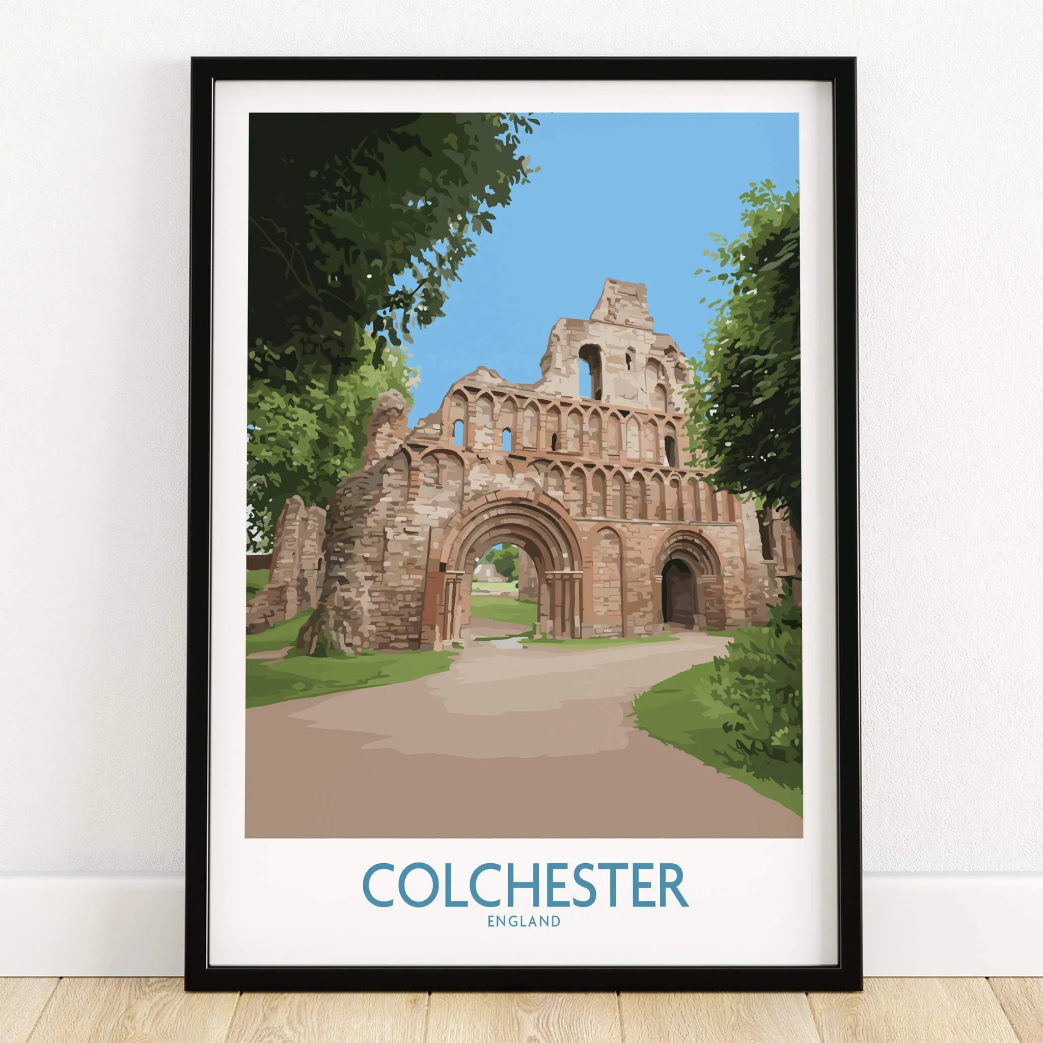 Framed Colchester England travel poster with historic ruins artwork on wooden floor