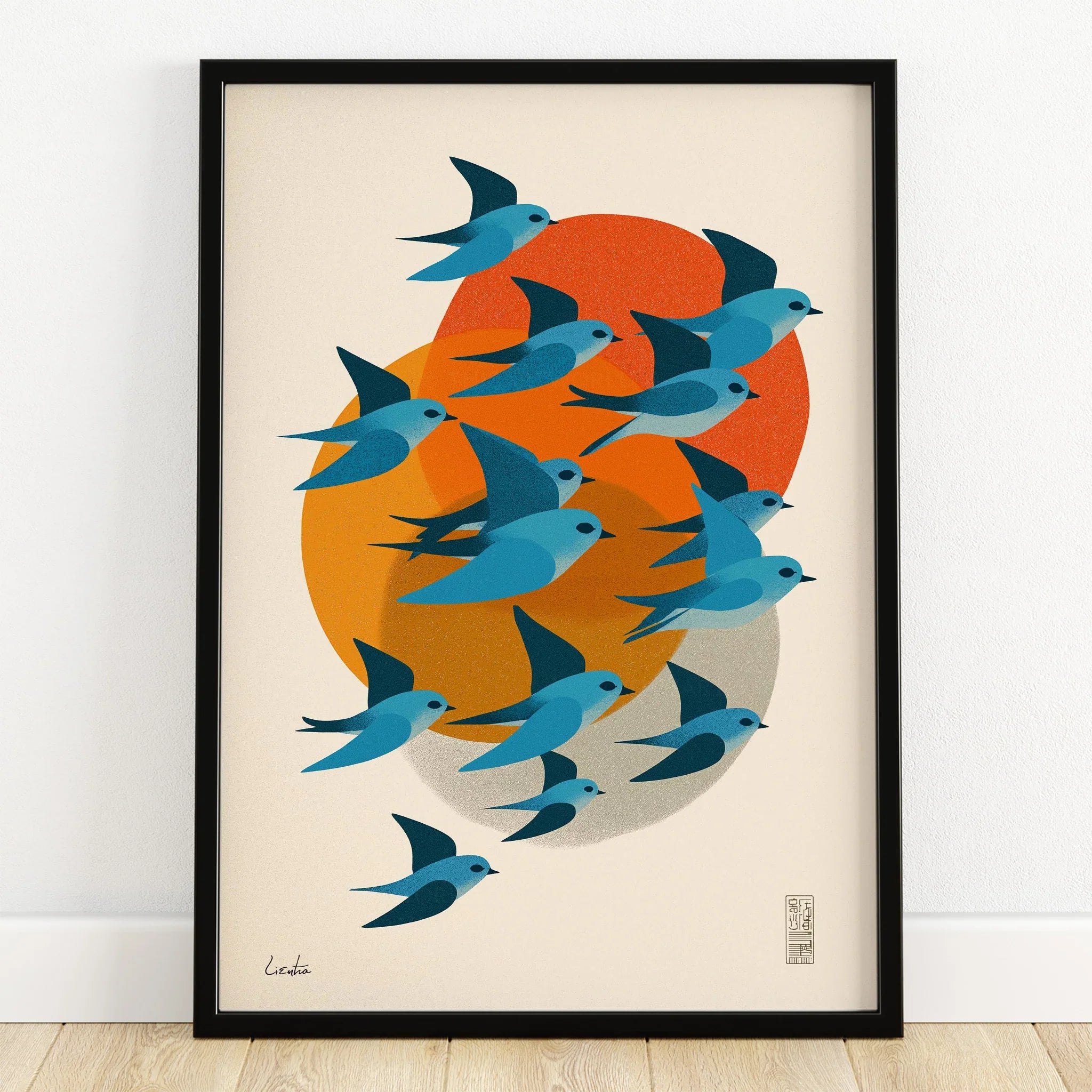 Modern art print of blue birds flying with orange and yellow abstract shapes in black frame