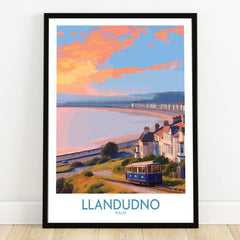 Llandudno travel poster art print in black frame showing tram, coast, and colorful sky
