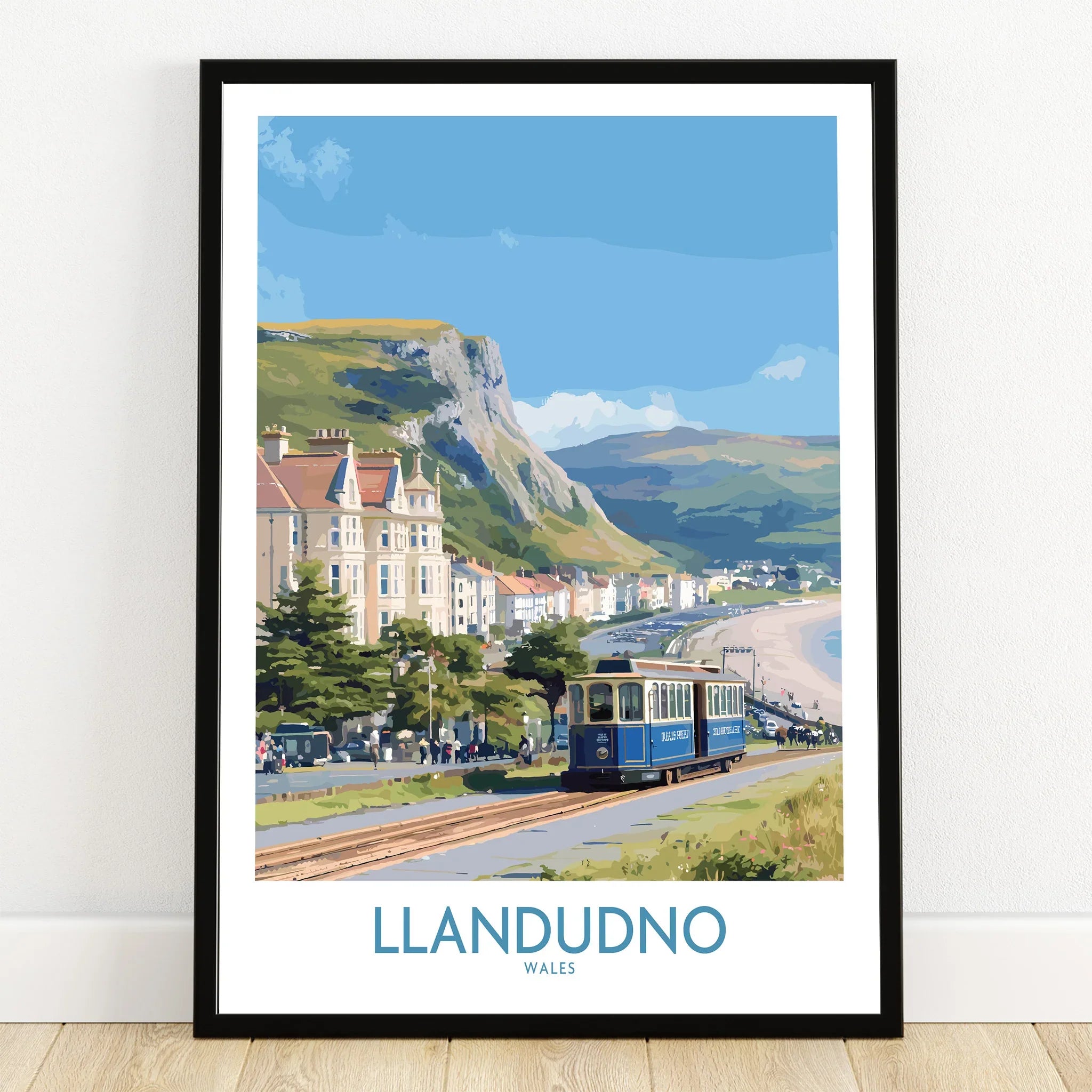 Llandudno Wales art print with seaside tram, Victorian buildings, coastal cliffs and beach in black frame