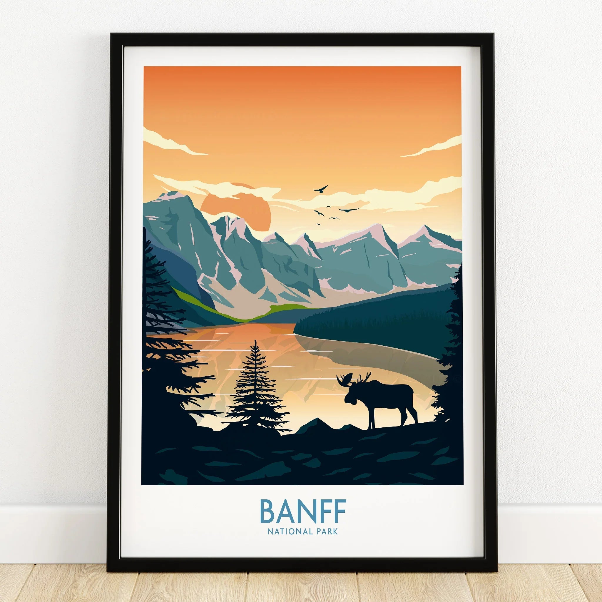 Banff National Park art print with mountains, lake, moose silhouette, and sunset in black frame