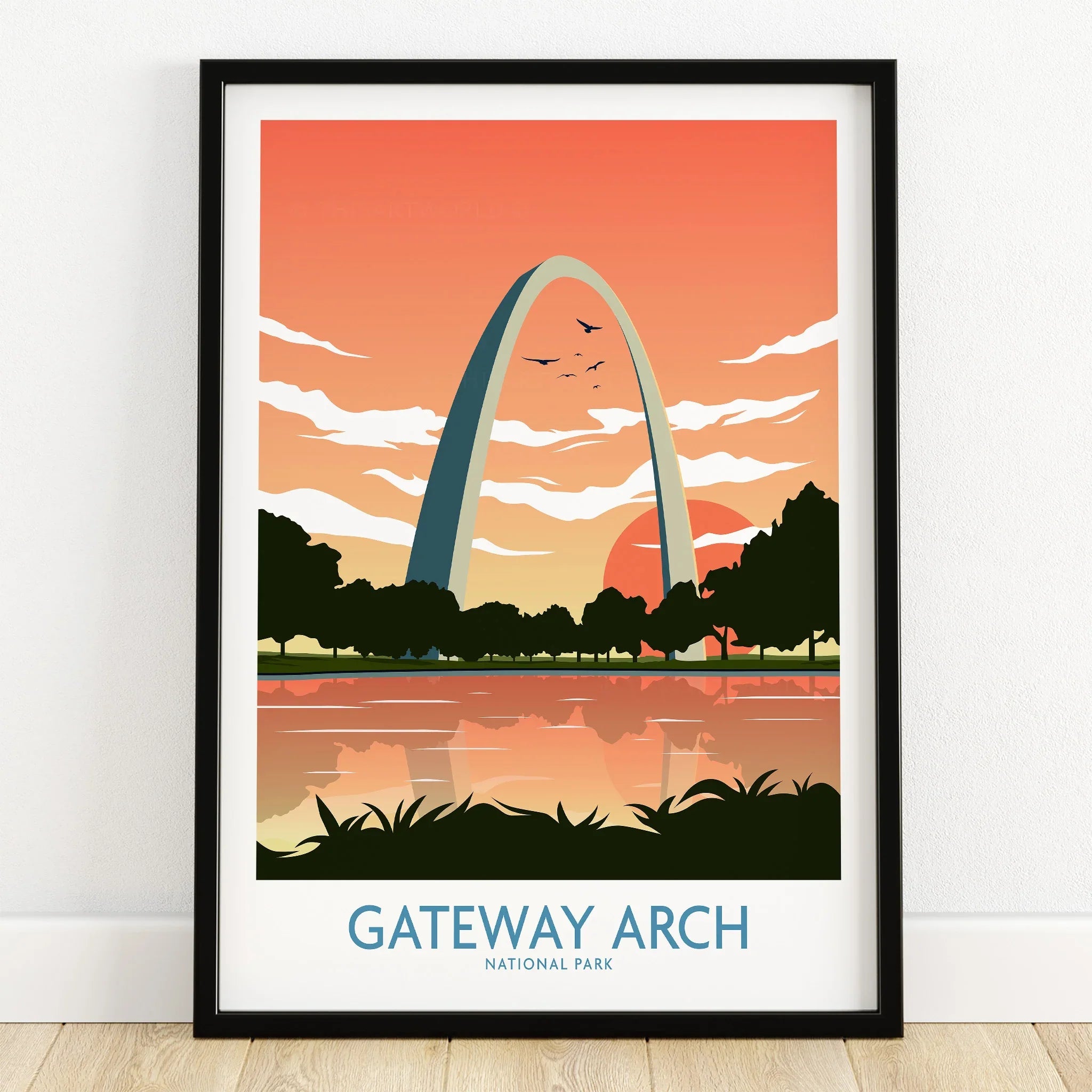 Gateway Arch National Park art print in black frame on wooden floor, sunset background