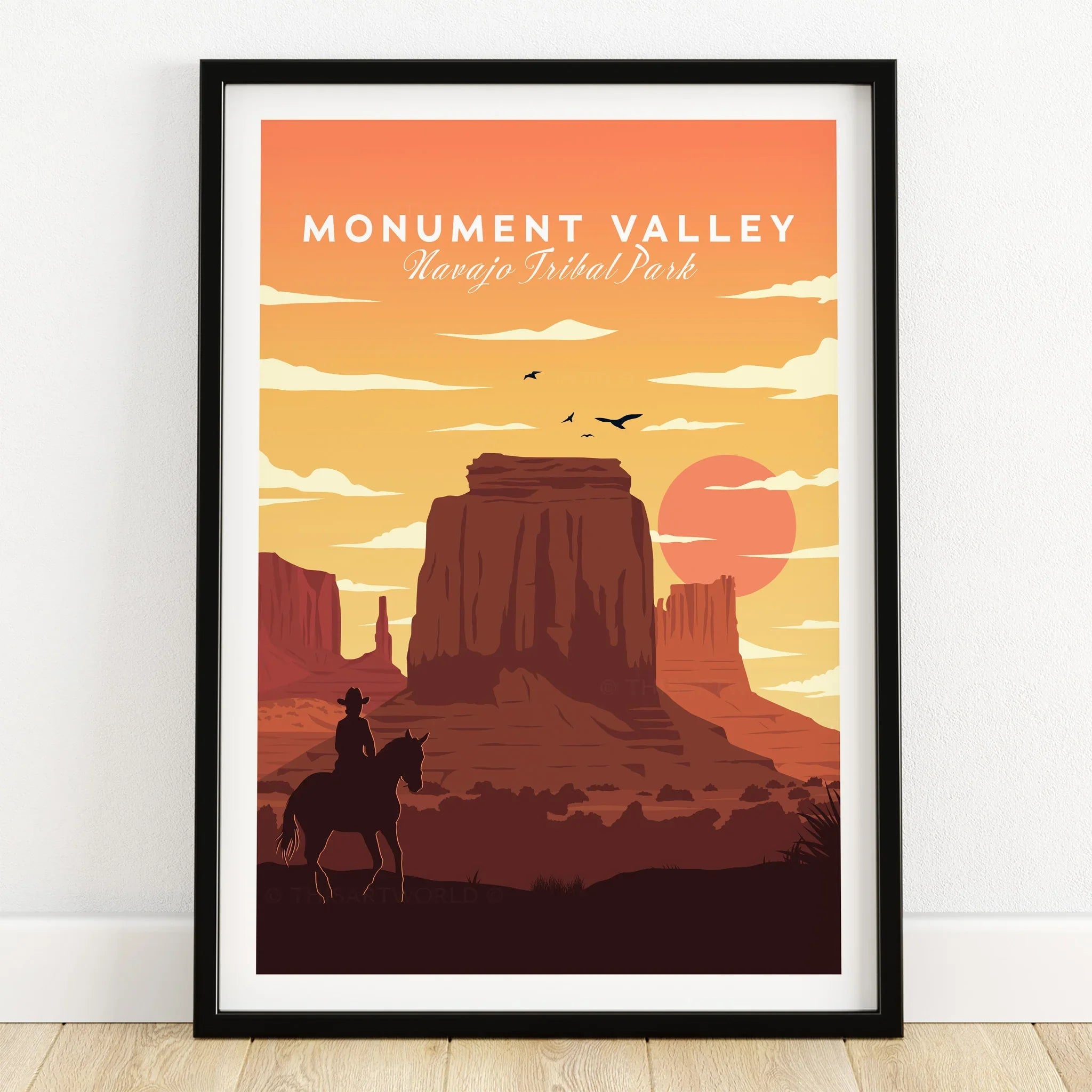 Monument Valley art print in black frame, with desert sunset and cowboy silhouette.