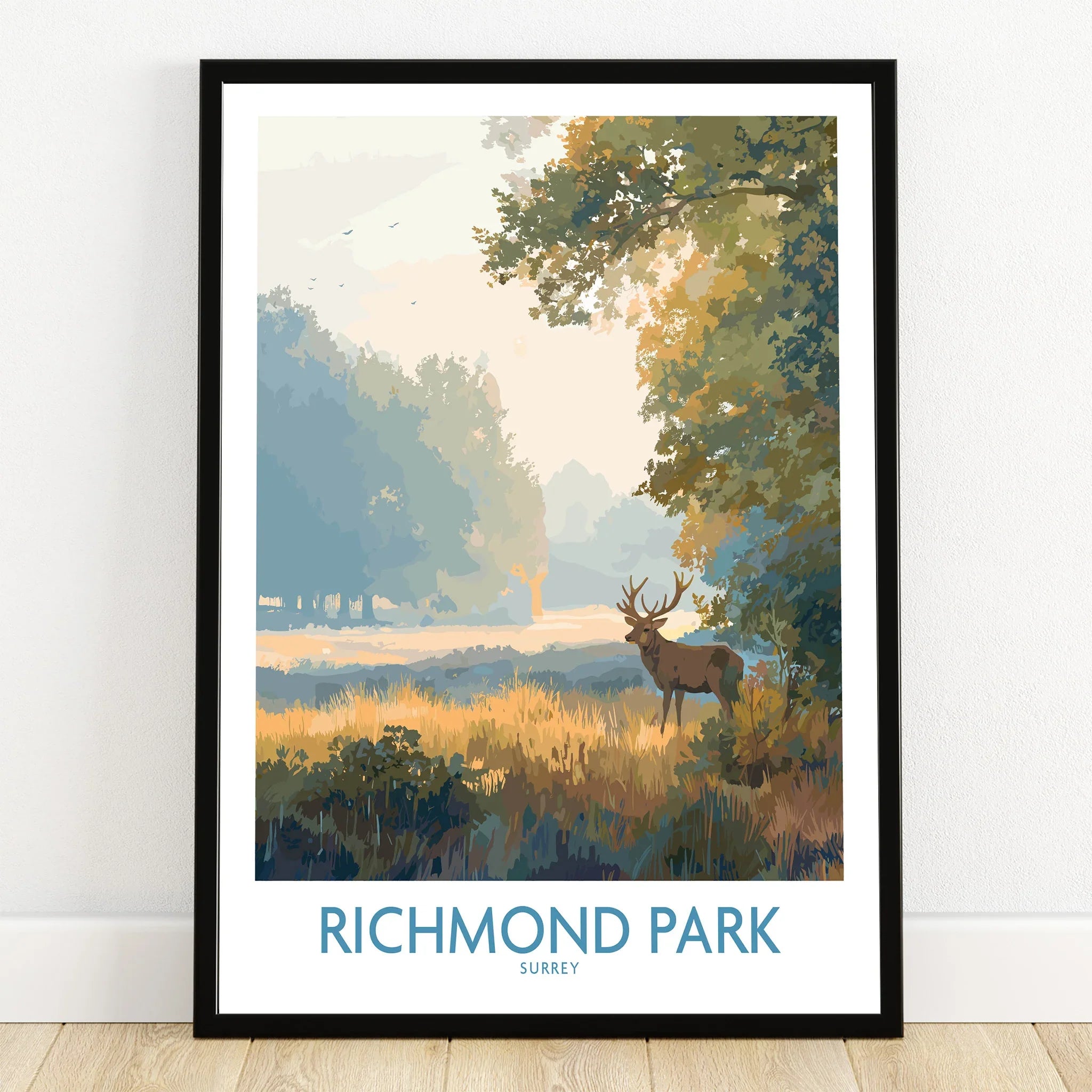 Richmond Park art print in black frame, featuring a stag in a scenic landscape, on wooden floor
