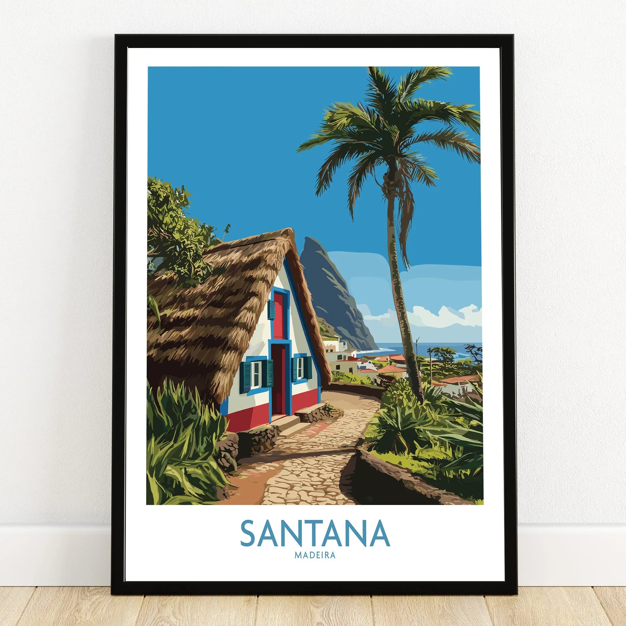 Santana Madeira art print in black frame, featuring a thatched house, palm tree, and coastal view.