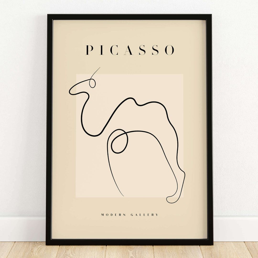Picasso Camel Line Art Minimalist Animal Poster Modern Gallery Print Wall Art framed in a black frame on a wooden floor.