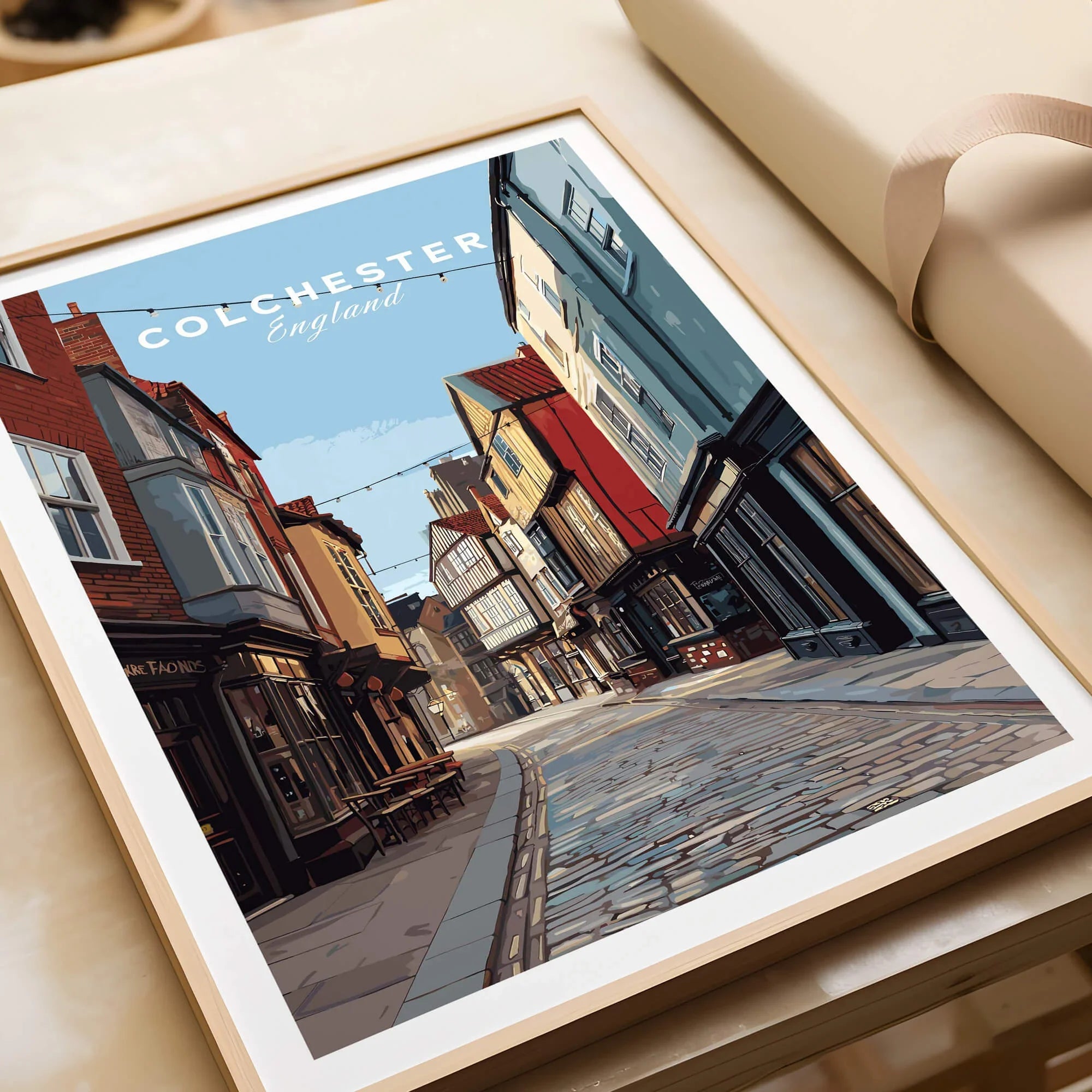 Framed Colchester England travel art print with cobblestone street and historic buildings