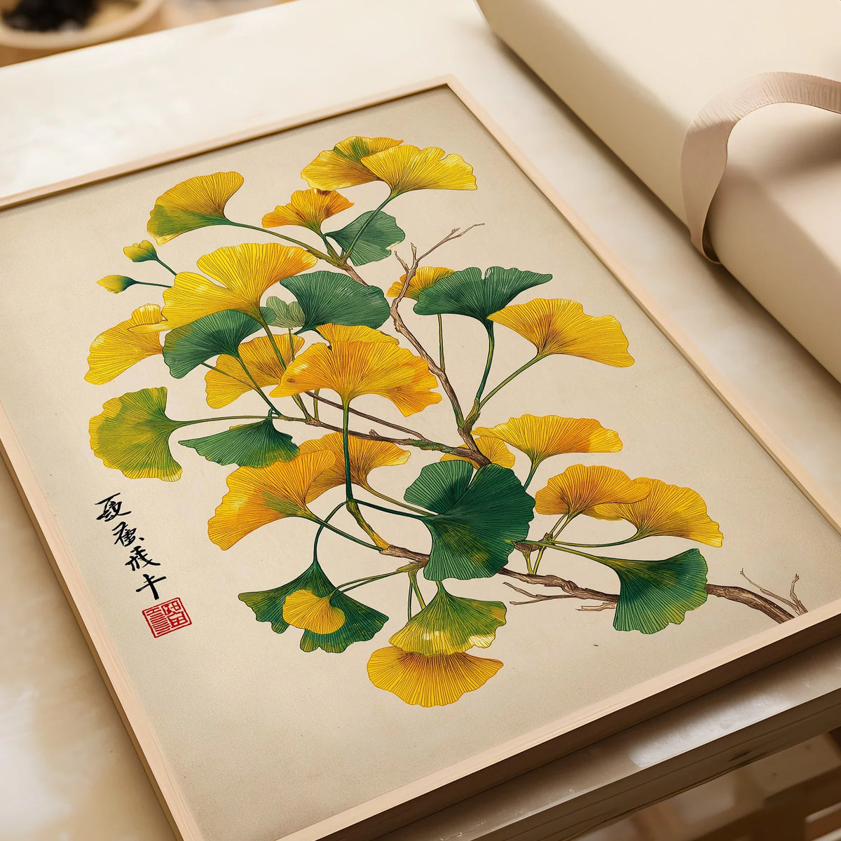 Framed art print of ginkgo tree leaves in green and yellow, unwrapped, on a light background