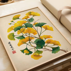 Framed art print of ginkgo tree leaves in green and yellow, unwrapped, on a light background