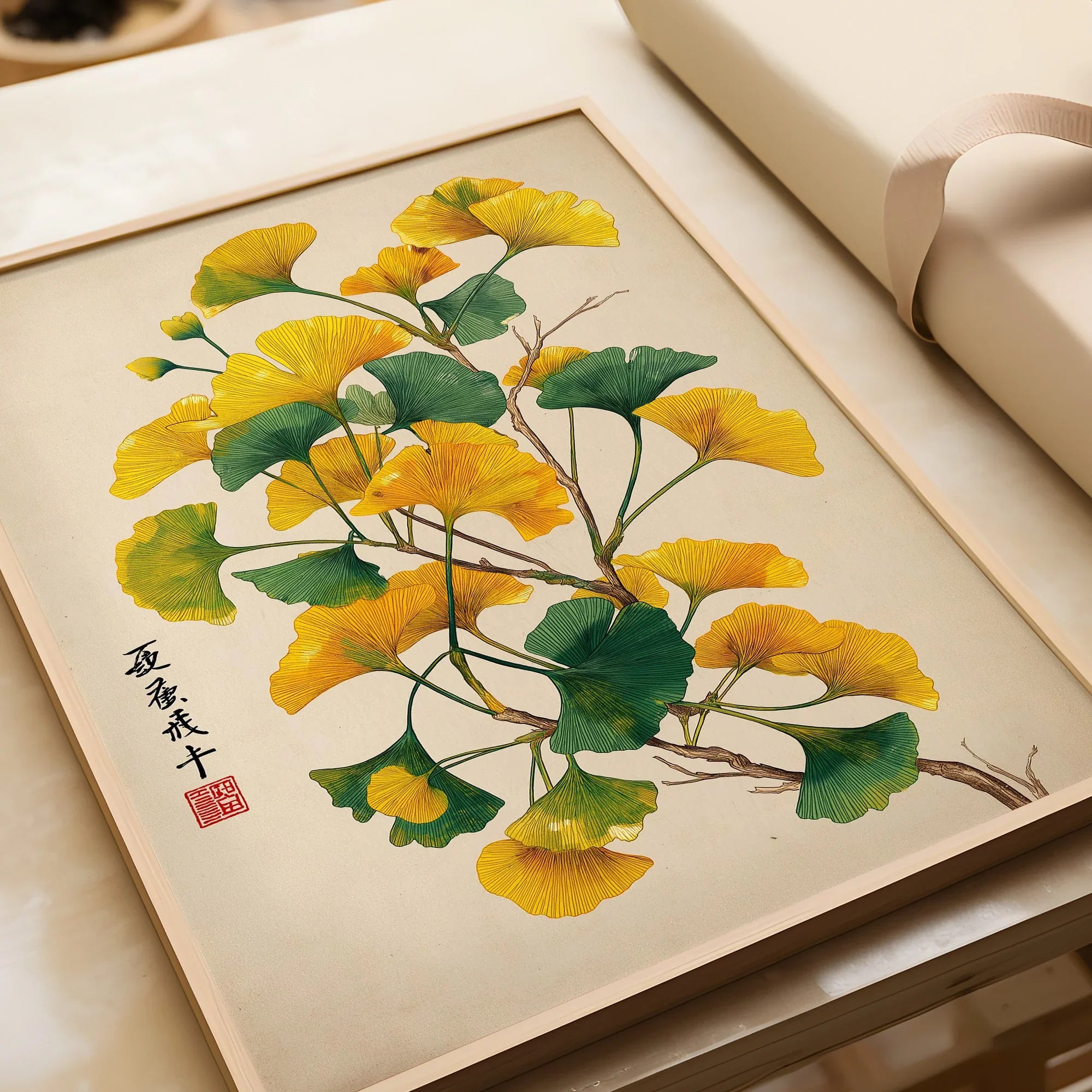 Framed art print of ginkgo tree leaves in green and yellow, unwrapped, on a light background