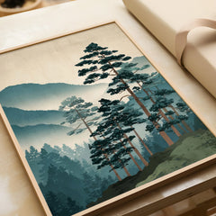 Framed woodblock art print of misty pine trees and mountains, unwrapped as a gift