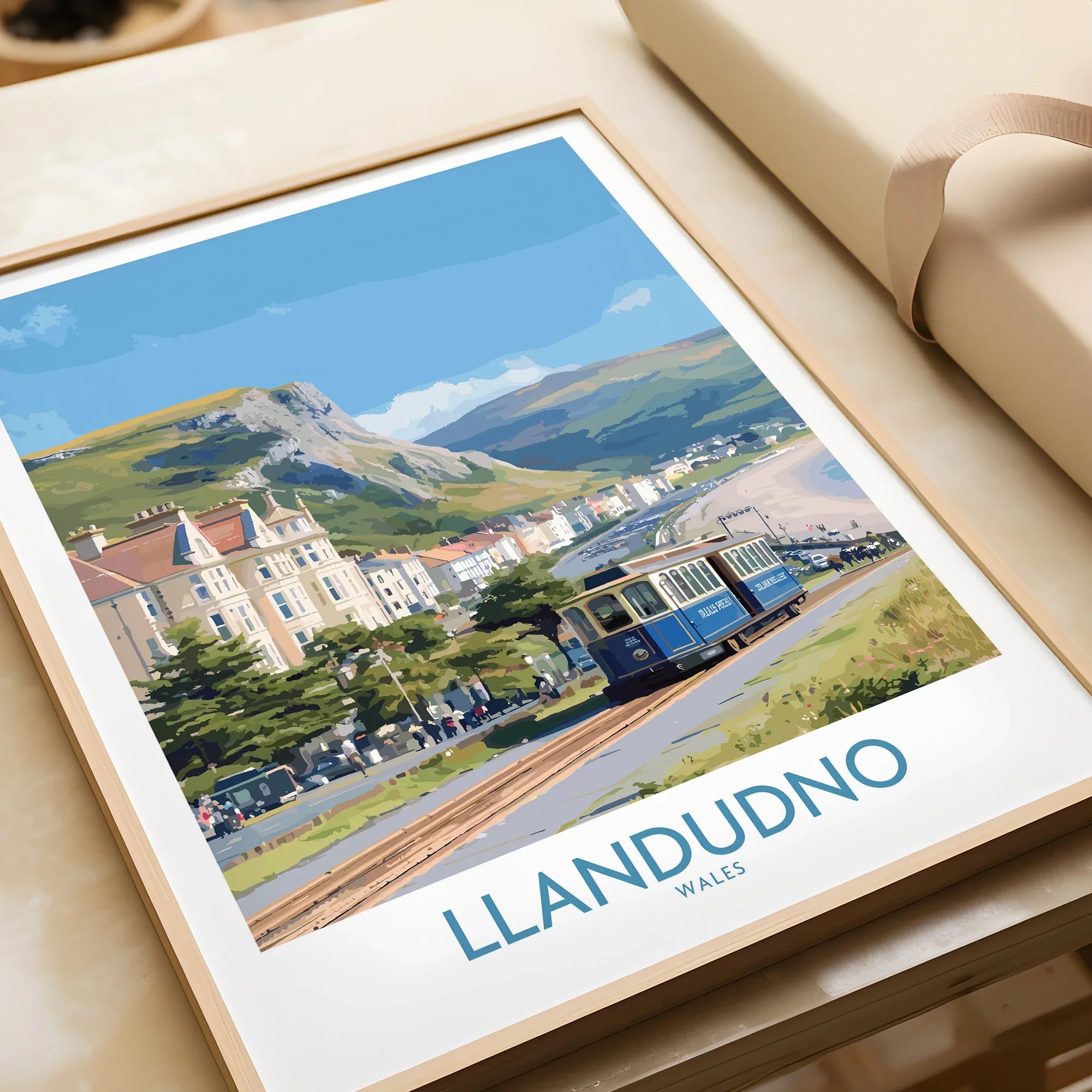 Framed Llandudno Wales travel art print with tram, coastal town, and scenic hills.