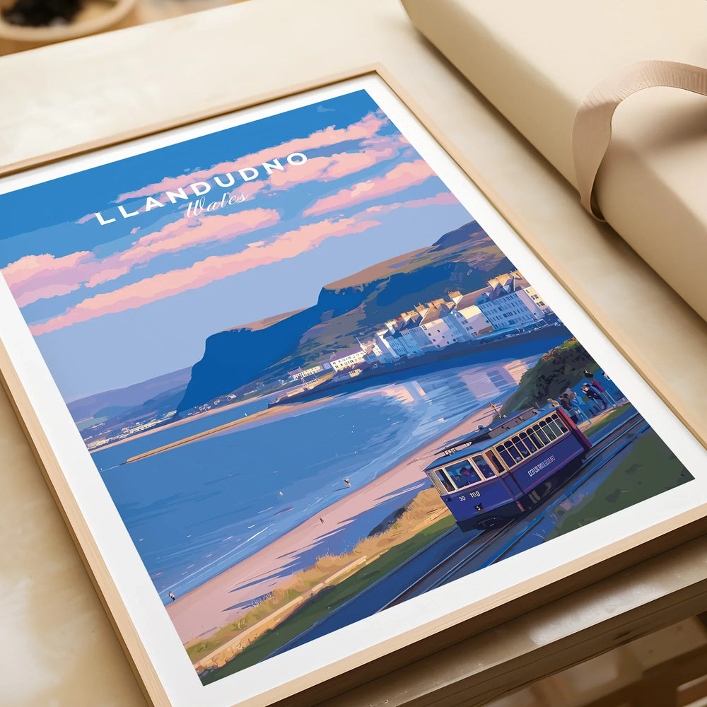 Framed Llandudno Wales art print featuring coastal tram, beach, and pastel sky.
