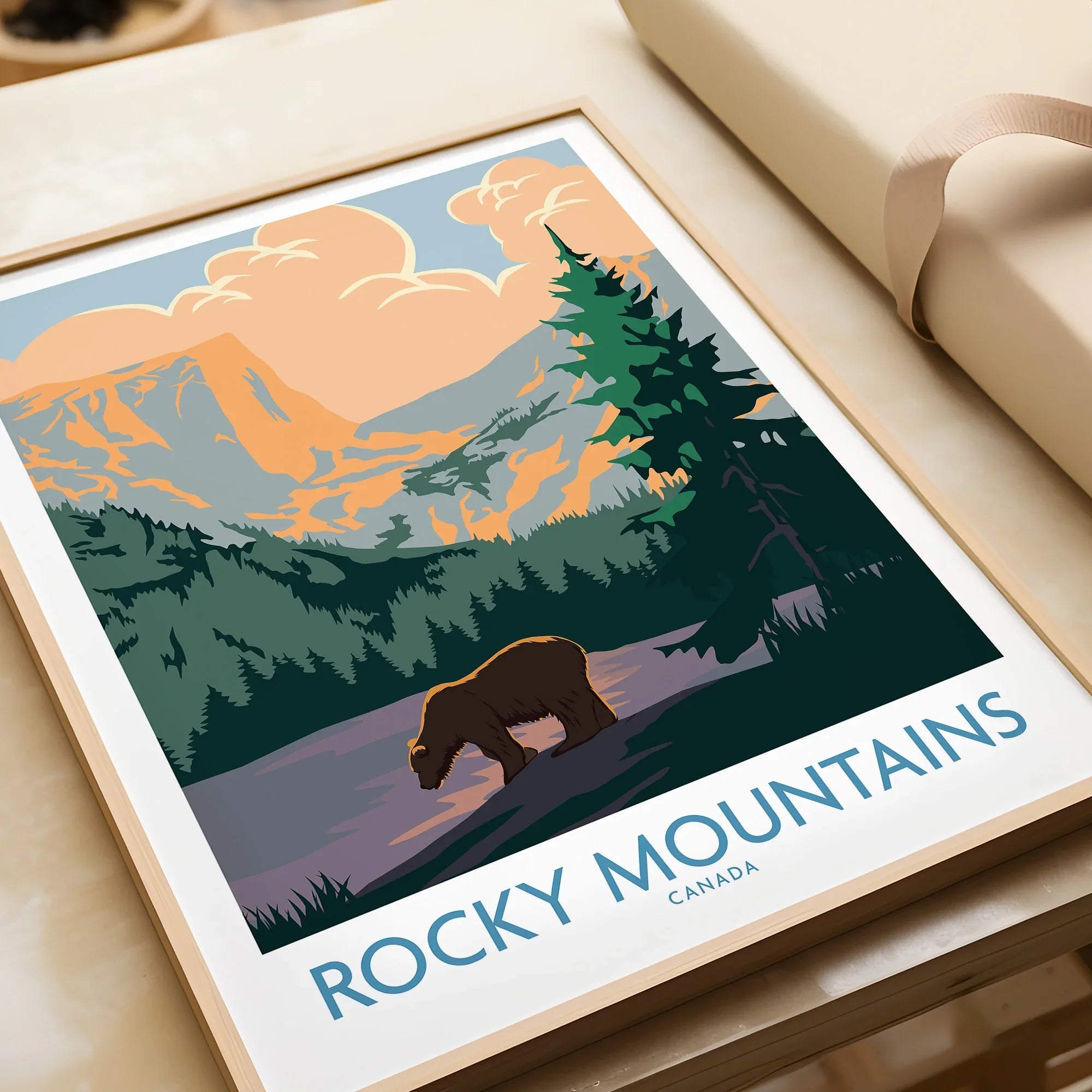 Framed Rocky Mountains travel poster with bear, pine trees, and sunset illustration
