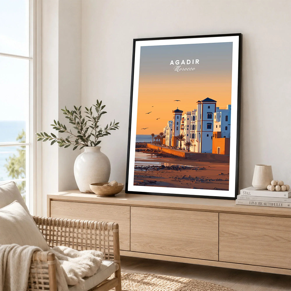 Agadir Travel Poster – Morocco Beach Print in a black frame displayed on an oak sideboard in a bright coastal living room