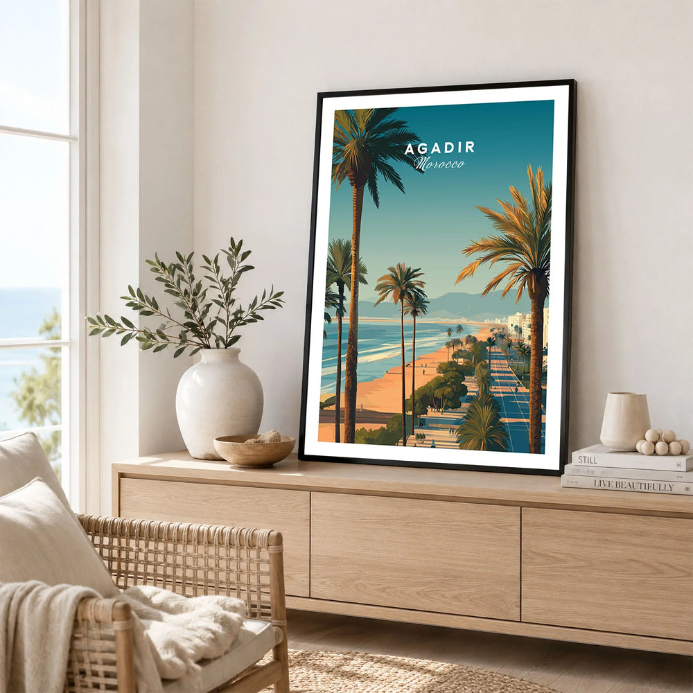 Agadir Travel Poster Print Morocco - Palm Trees in a black frame displayed on an oak sideboard in a bright coastal living room
