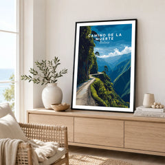 Camino de la Muerte Poster Bolivia Wall Art in a black frame displayed on an oak sideboard in a bright coastal living room