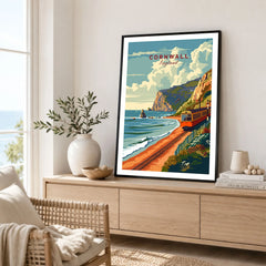 Cornwall Coast Travel Print in a black frame displayed on an oak sideboard in a bright coastal living room