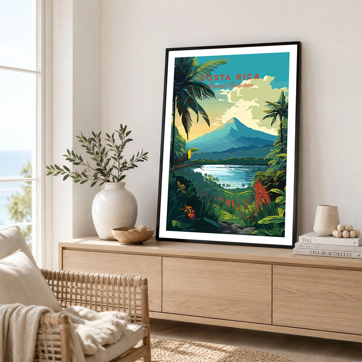 Costa Rica Print in a black frame displayed on an oak sideboard in a bright coastal living room