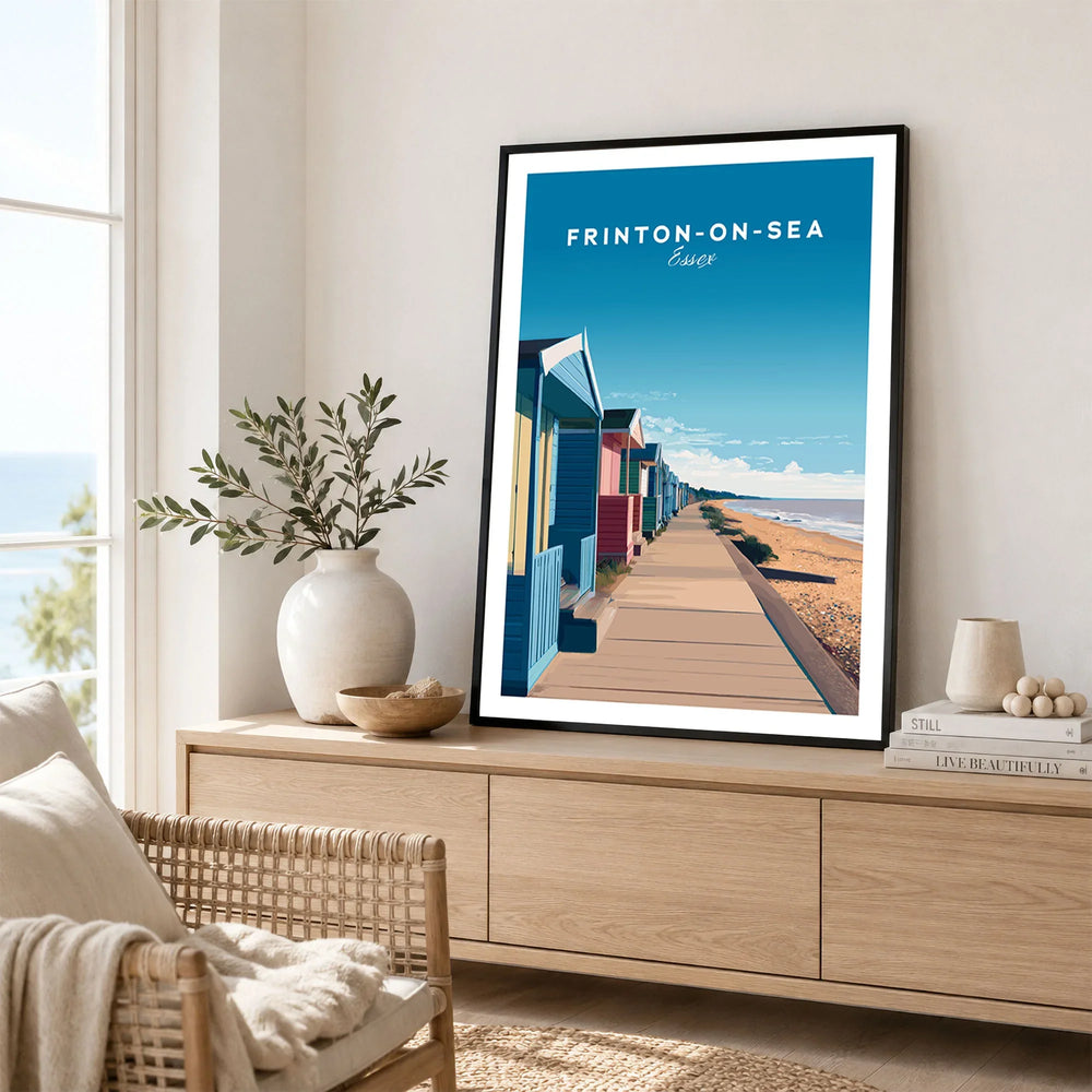 Frinton-on-Sea Travel Poster – Essex Coastline Beach Huts & Prom Art in a black frame displayed on an oak sideboard in a bright coastal living room