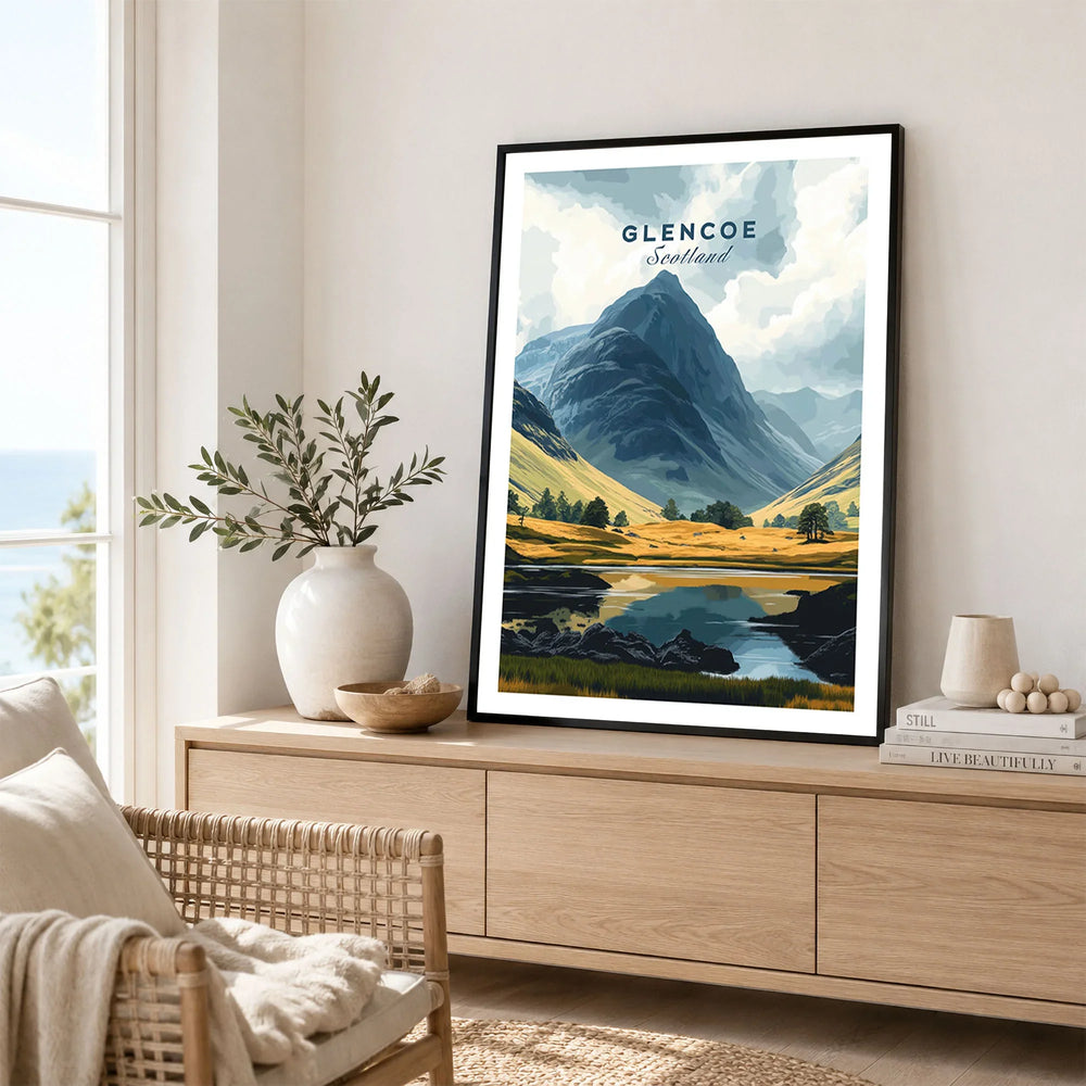 Glencoe Travel Print in a black frame displayed on an oak sideboard in a bright coastal living room