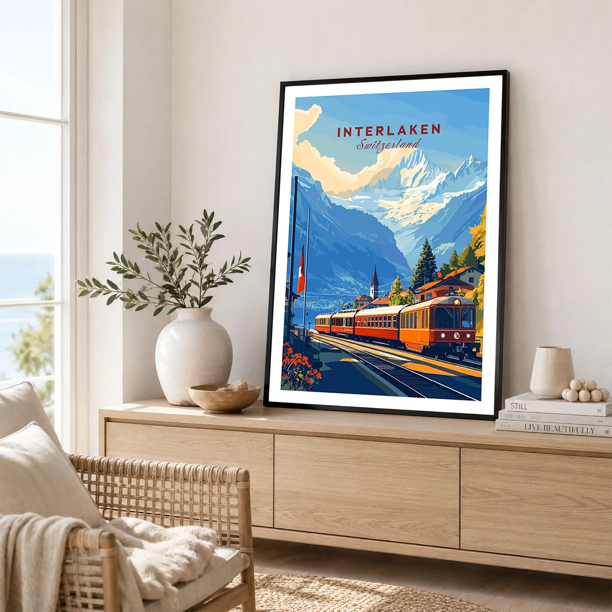 Interlaken Wall Art in a black frame displayed on an oak sideboard in a bright coastal living room