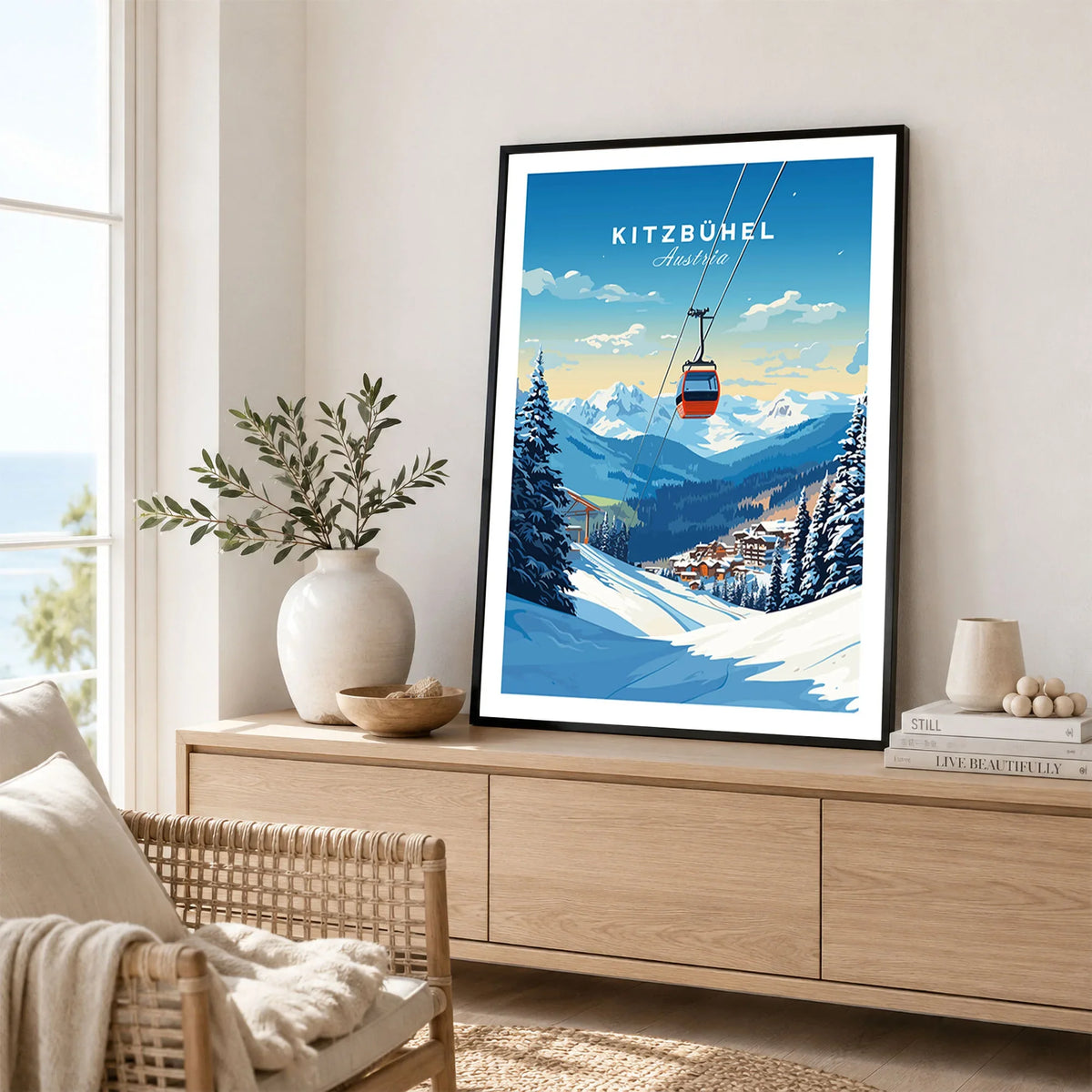 Kitzbuhel Art Print in a black frame displayed on an oak sideboard in a bright coastal living room