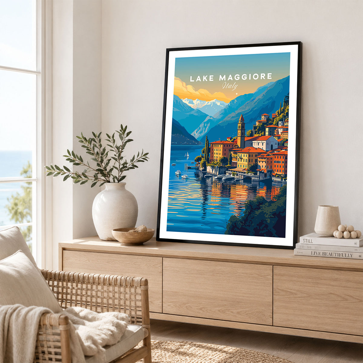 Lake Maggiore Print in a black frame displayed on an oak sideboard in a bright coastal living room
