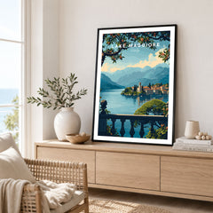 Lake Maggiore Travel Poster in a black frame displayed on an oak sideboard in a bright coastal living room