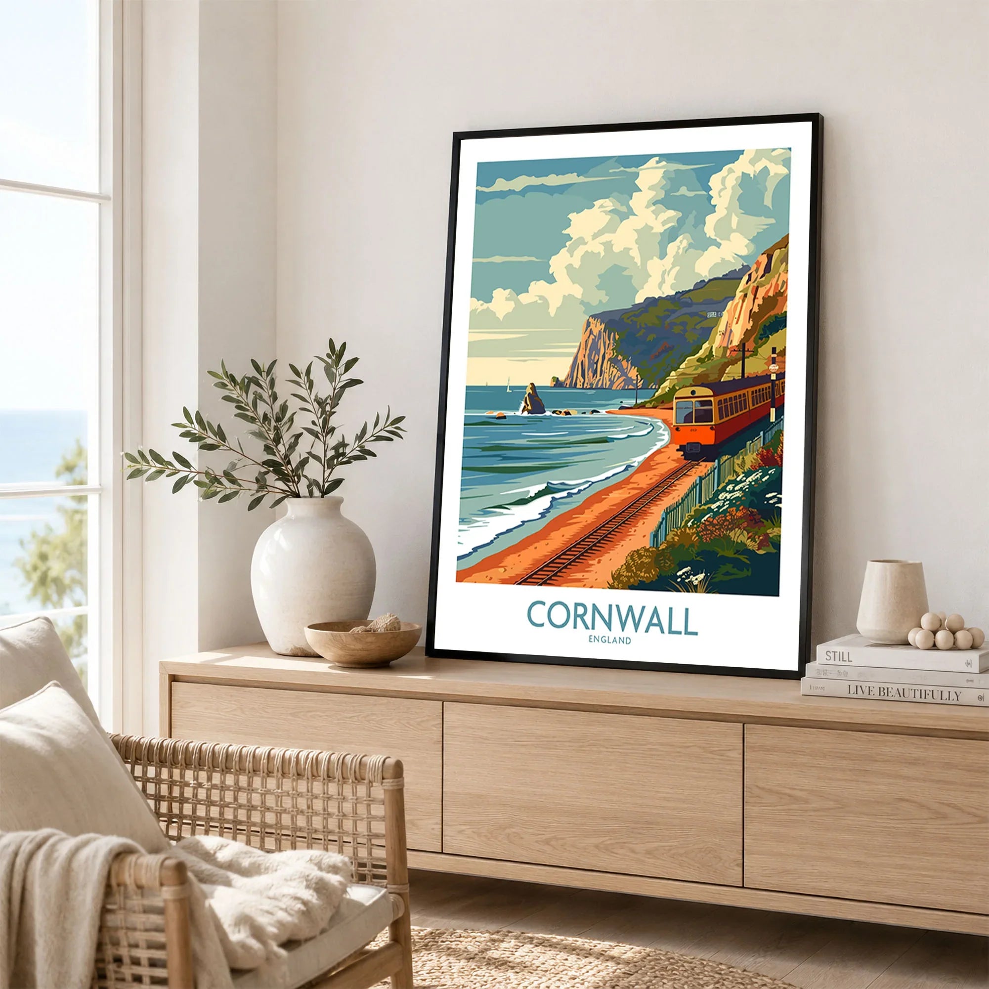 Cornwall Coast Wall Art Print in a black frame displayed on an oak sideboard in a bright coastal living room