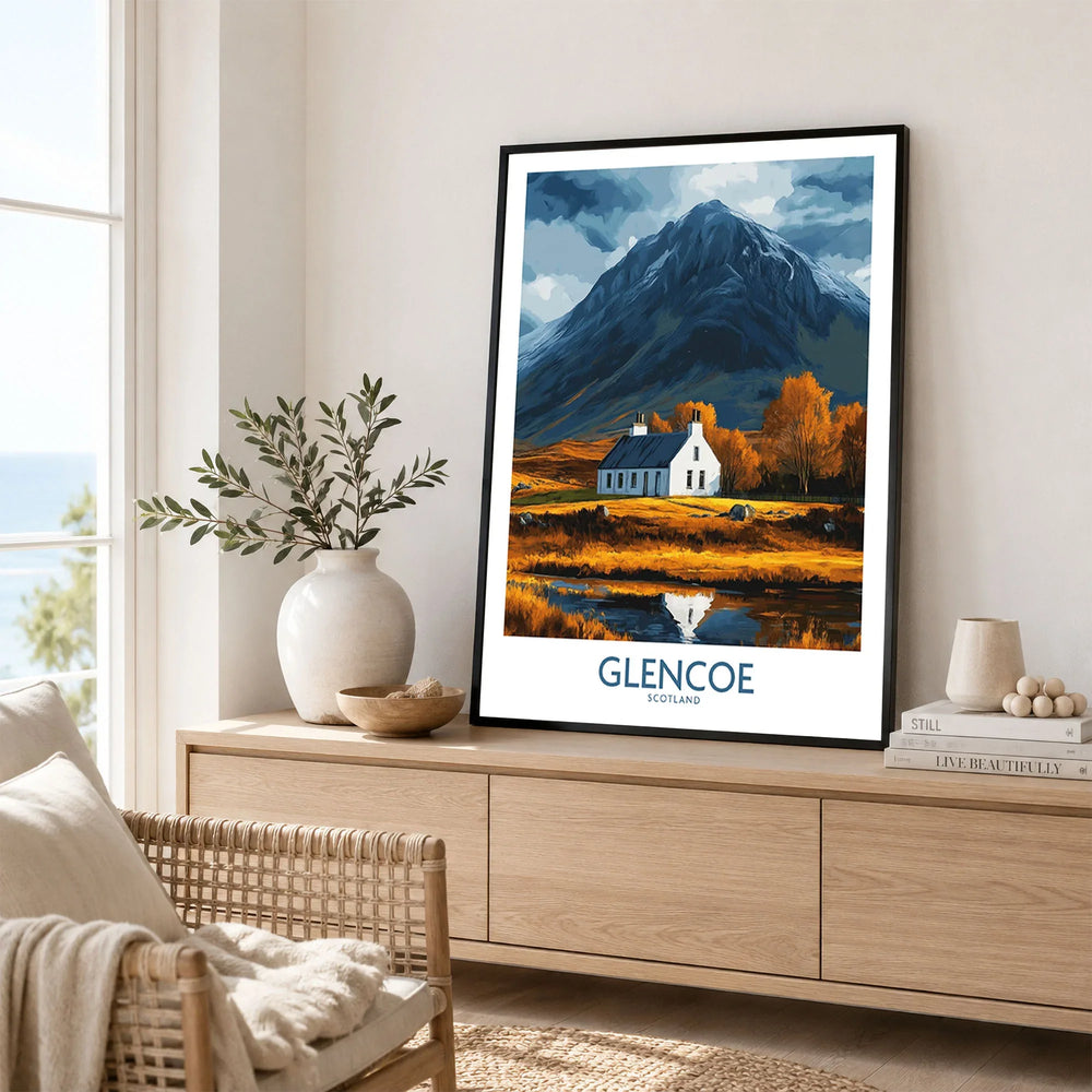 Glencoe Scotland Print in a black frame displayed on an oak sideboard in a bright coastal living room
