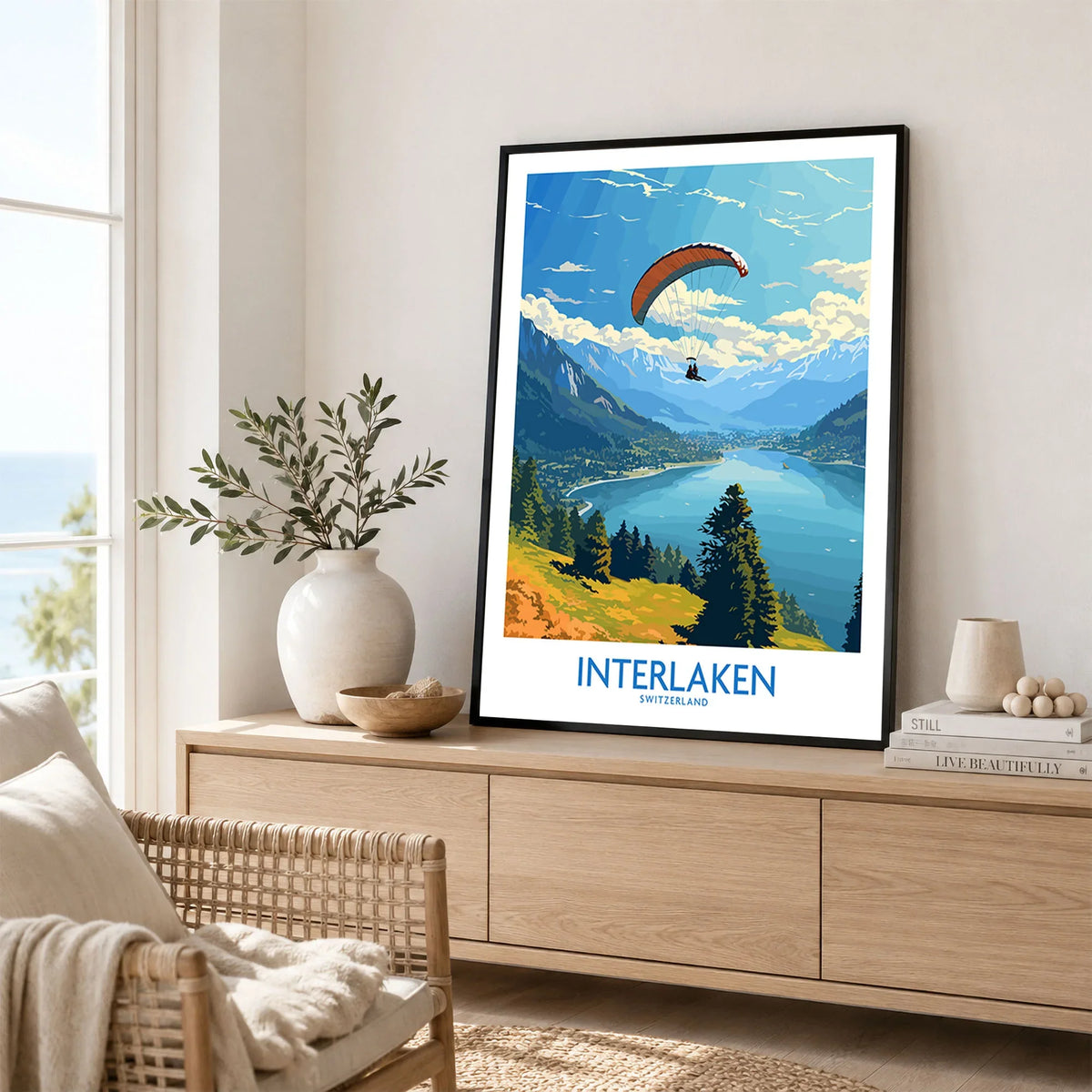 Interlaken Wall Art Print in a black frame displayed on an oak sideboard in a bright coastal living room